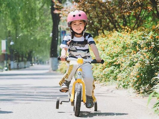 Bé gái vui vẻ và hứng khởi khi tập đạp xe